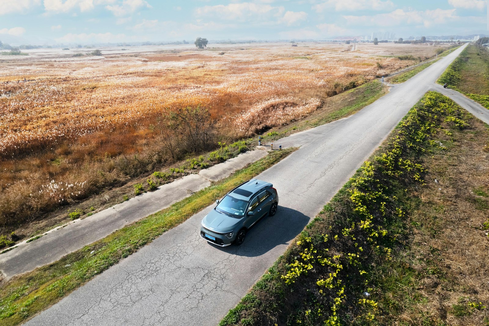 Aerial view of a car driving along a winding country road
