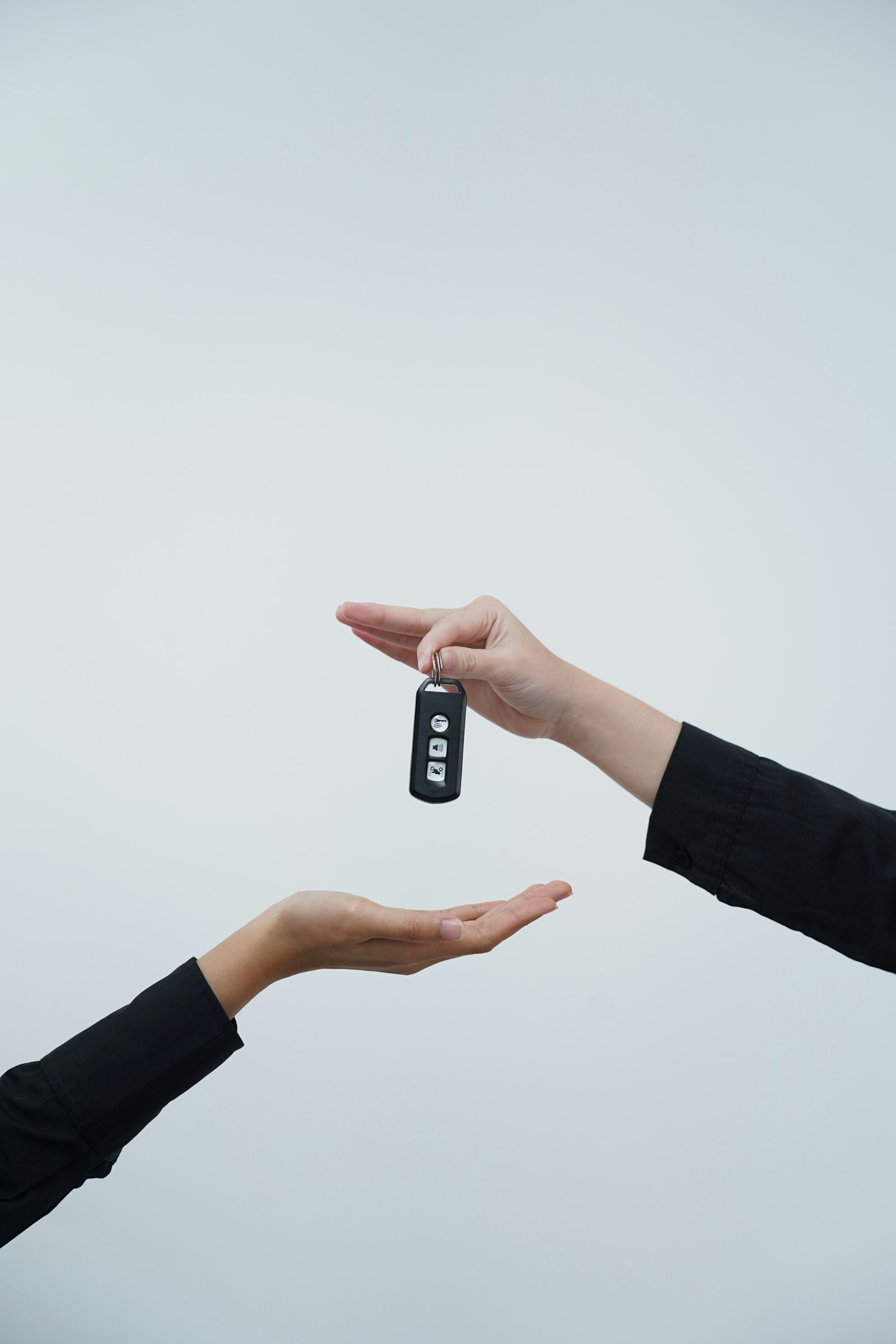 Two hands exchanging a set of car keys
